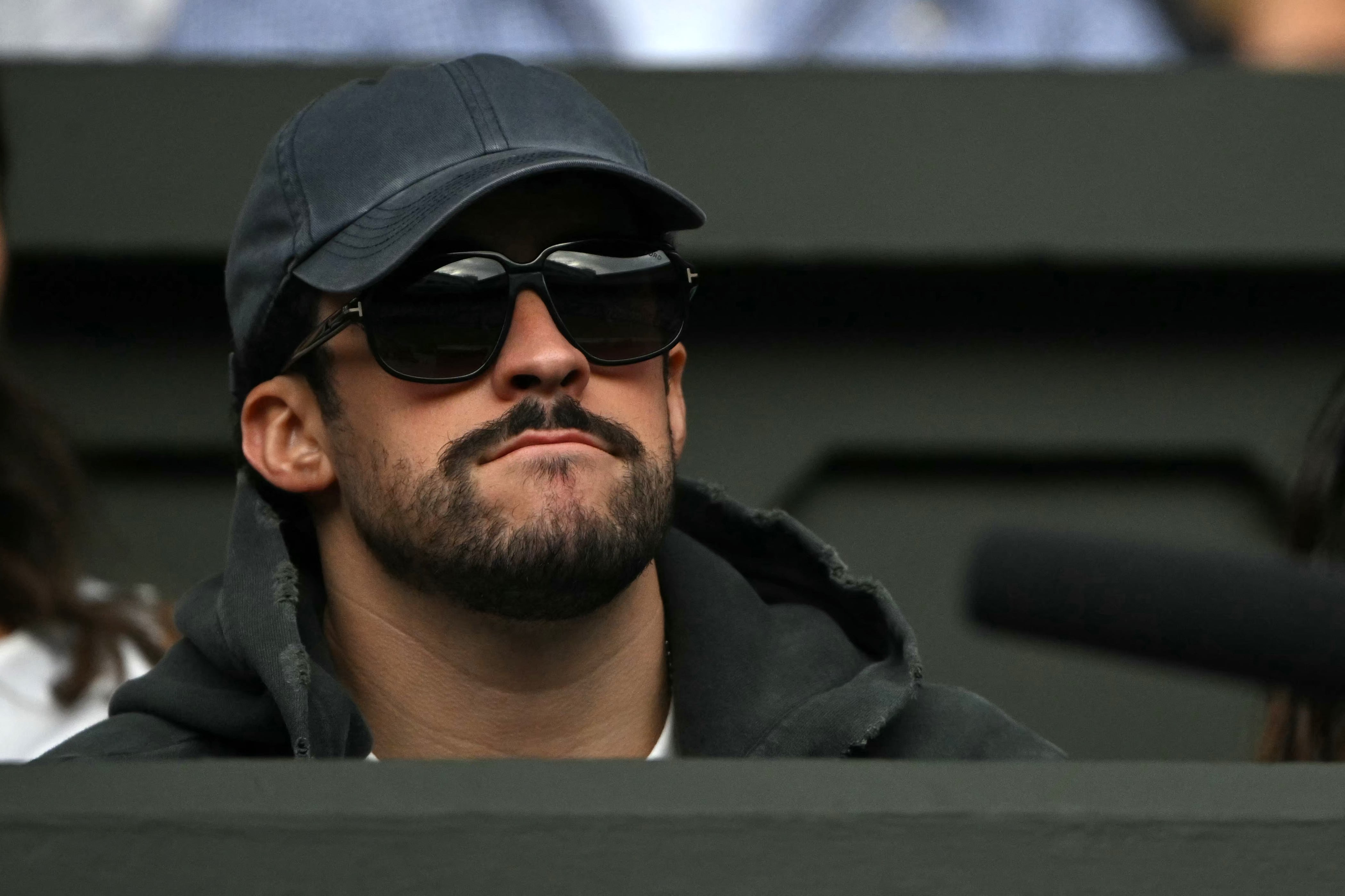 Bad Bunny observa cómo el chino Yibing Wu se enfrenta al serbio Novak Djokovic durante su partido de primera ronda del torneo individual masculino de tenis, en la primera jornada del Campeonato de Wimbledon de 2026, celebrado en el All England Lawn Tennis and Croquet Club de Wimbledon, al suroeste de Londres, el 29 de junio de 2026.