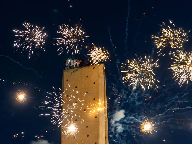 DAMASCUS, SYRIA - DECEMBER 13: Fireworks light up the night sky as people gather in Umayyad Square to celebrate the collapse of the 61-year-long Baath regime and the end of the Assad family era in Damascus, Syria on December 13, 2024. People climbed structures, waving flags and capturing the moment on their phones. (Photo by Emin Sansar/Anadolu via Getty Images)