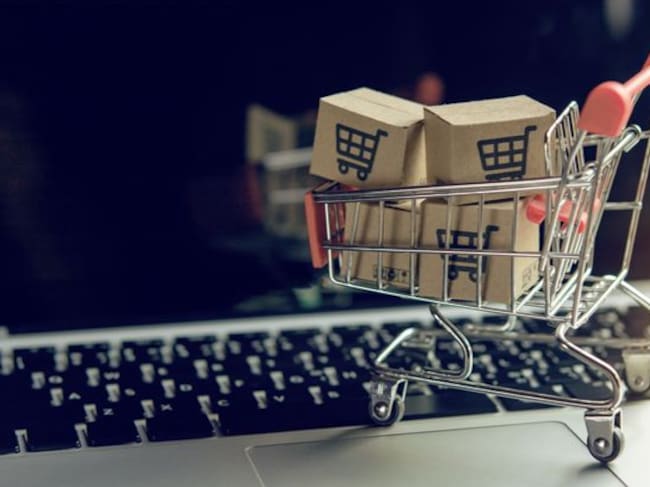 Shopping online concept - Parcel or Paper cartons with a shopping cart logo in a trolley on a laptop keyboard. Shopping service on The online web. offers home delivery.
