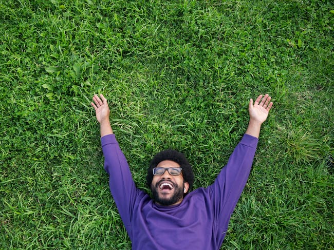 Hombre feliz tirado en el césped