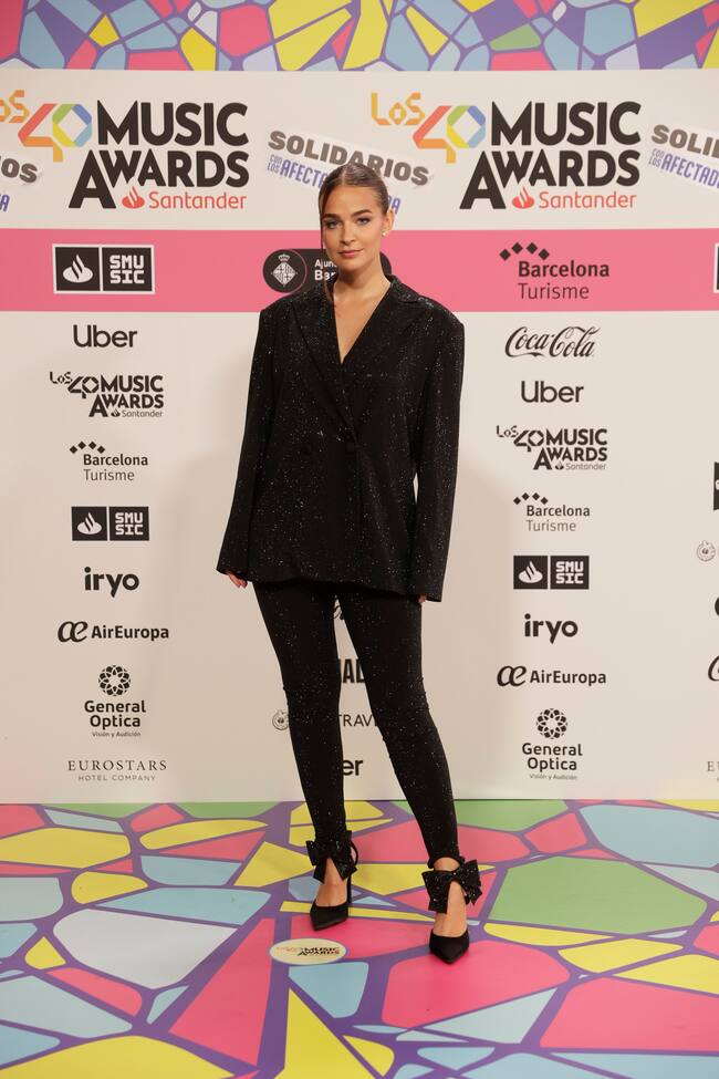 Laura Escanes, con una chaqueta brillante oversize, ha dejado el detalle más 'coquette' en sus tobillos.