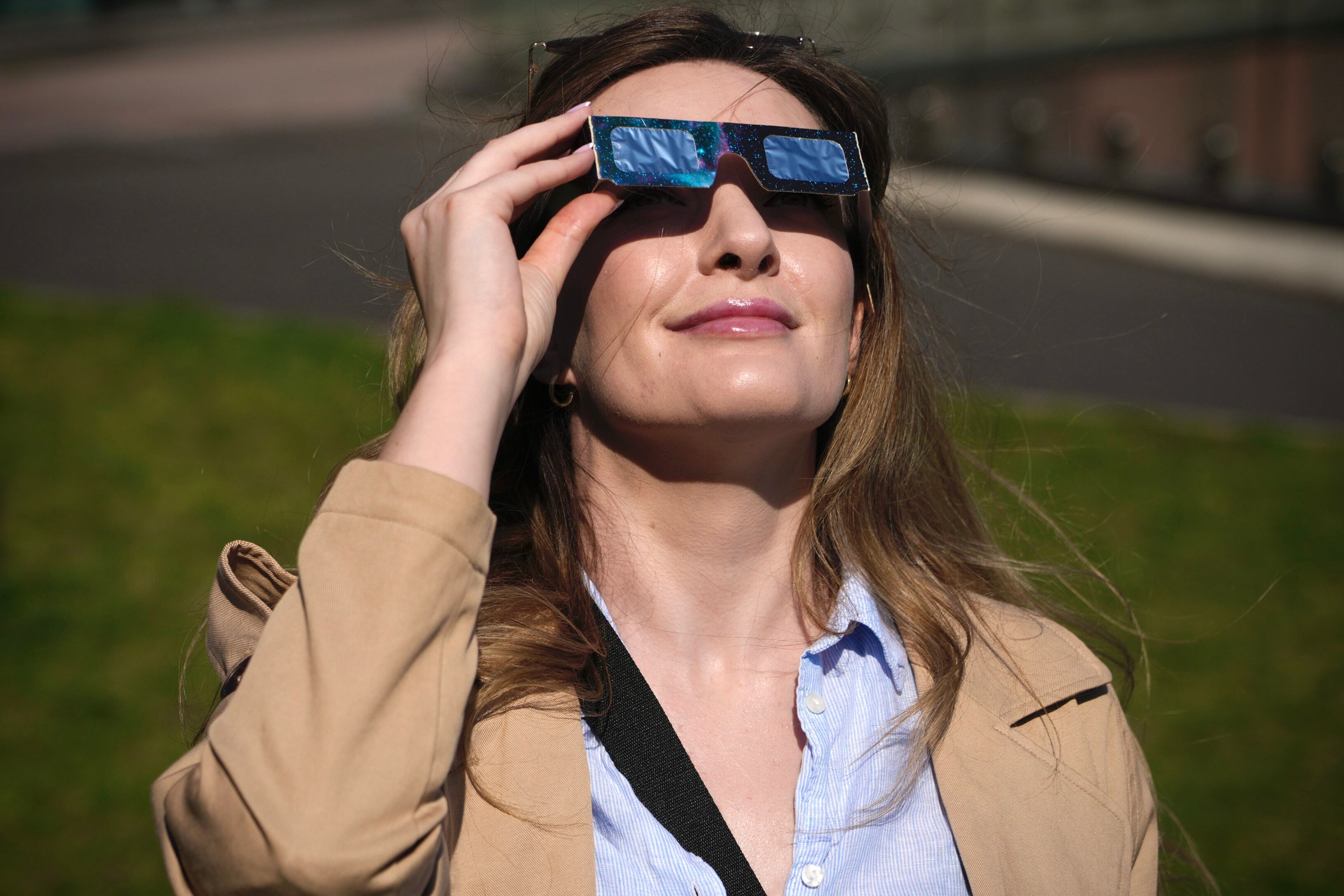 Una mujer observa el eclipse con sus gafas