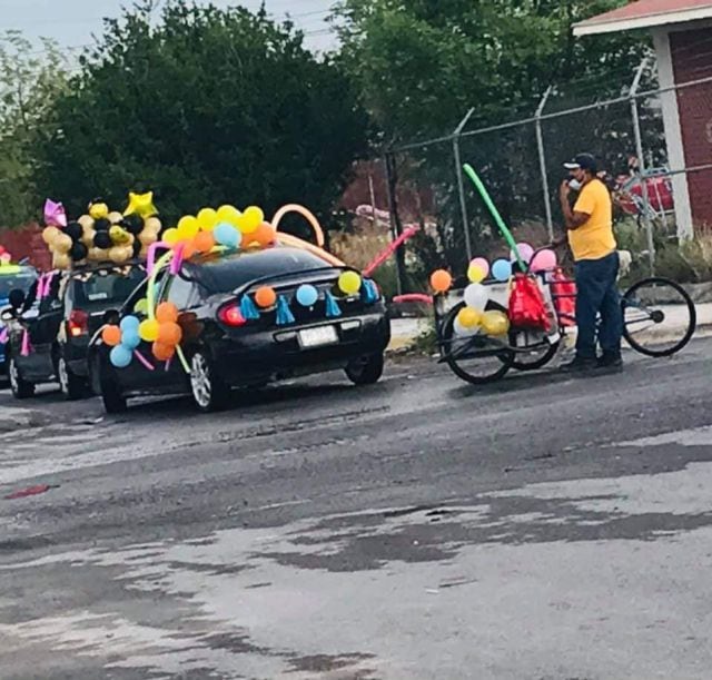 Papá lleva su triciclo para formar parte de la caravana de escolar de su hijo