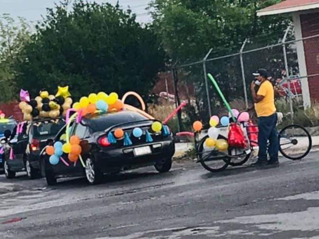 Papá lleva su triciclo para formar parte de la caravana de escolar de su hijo